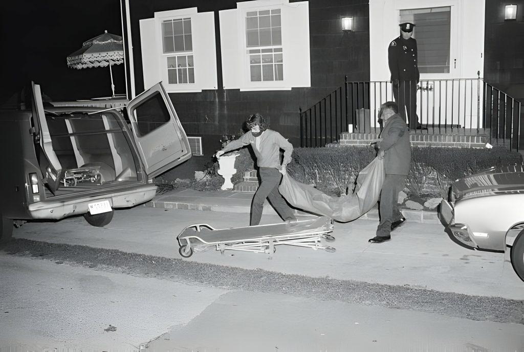 14 novembre 1974 - Due membri dell'ufficio del coroner rimuovono uno dei sei corpi